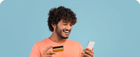 happy-indian-guy-holding-cell-phone-credit-card 1